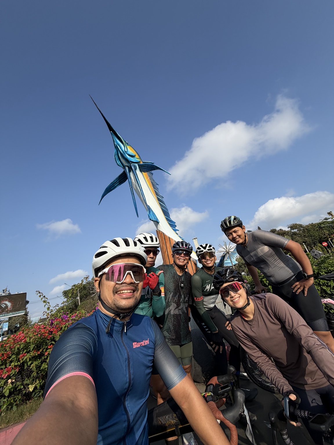 A group of six cyclists sharing a sunny moment together
